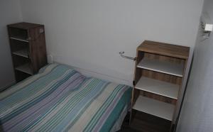 a small bedroom with a bed and shelves at Ferienwohnung Homeyer in Schilksee