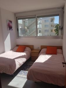 2 camas en una habitación con ventana en Apartamento ELEGANCE Siesta - DENIA, en Denia