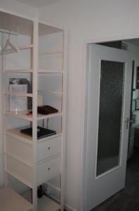 a closet with white shelves and a door at Ferienwohnung Homeyer in Schilksee