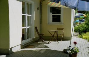 eine Terrasse mit einem Sonnenschirm, einem Tisch und Stühlen in der Unterkunft Ferienwohnung Prophet in Kiel
