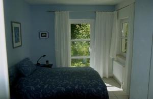 a bedroom with a bed and two windows at Ferienwohnung Prophet in Kiel
