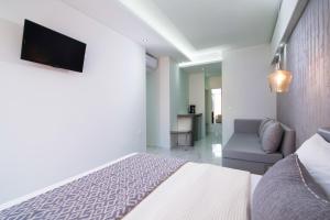 a bedroom with a bed and a tv on a wall at Molos Hotel in Limenaria