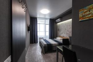 基輔的住宿－Solo Apartment Virmenska，酒店客房设有床、桌子和窗户。