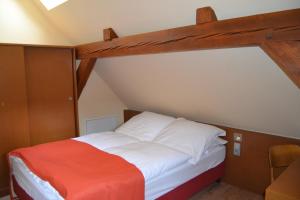 - une chambre avec un grand lit à baldaquin en bois dans l'établissement Alte Schule Reichenwalde, à Reichenwalde