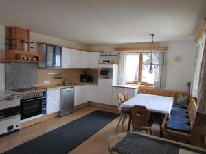 a kitchen with white cabinets and a table with chairs at Ferienhäusl Hubert und Staller in Kaltenbach