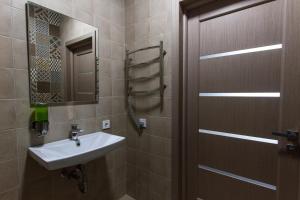 baño con lavabo, espejo y puerta en Solo Apartment Virmenska, en Kiev