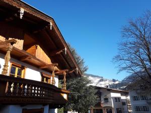 ein Gebäude mit einem Holzbalkon mit einem Berg im Hintergrund in der Unterkunft Ferienhäusl Hubert und Staller in Kaltenbach