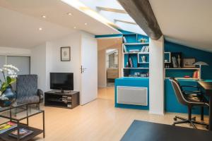 uma sala de estar com paredes azuis e uma secretária e cadeiras em Appartement 9 Place d'Alliance em Nancy