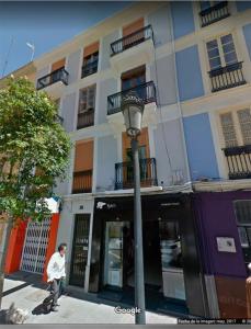 a man walking down a street in front of a building at FLORIT FLATS - Cozy Wifi AC Loft In the Heart of Ruzafa in Valencia