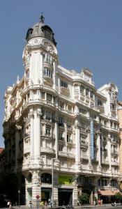 a large white building with a clock on top of it at Hotel Atlántico in Madrid
