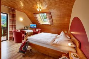 een slaapkamer met een bed in een houten kamer bij Haus am Kaltenbach in Enzklösterle