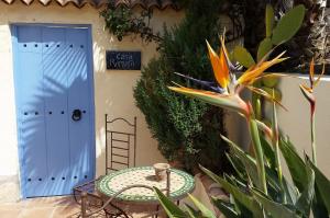 una mesa frente a una puerta con una flor en Casa Romero, en Lliber