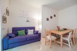 een woonkamer met een paarse bank en een tafel bij Lizzy Apartment in Milaan
