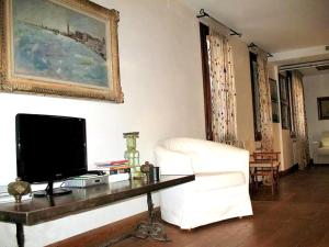 a living room with a television and a white couch at Venetian House With Terrace in Venice