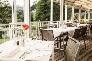 un ristorante con tavoli e sedie bianchi e finestre di Maltschacher Seewirt a Feldkirchen in Kärnten