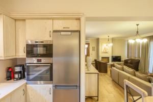a kitchen with a stainless steel refrigerator and a living room at Evgatis Beach Luxury Apts in Thános