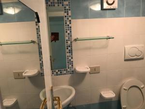 a bathroom with a sink and a toilet and a mirror at Flat Low cost in Sperlonga
