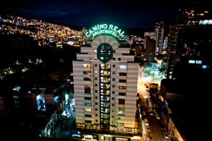 een gebouw met 's nachts een klok erop bij Camino Real Aparthotel, Downtown in La Paz