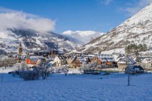a town covered in snow with mountains in the background at GRAN CHALET HOTEL & PETiT SPA WELLNESS in Vielha