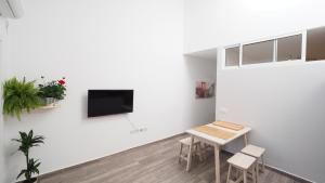 um quarto branco com uma mesa e uma televisão na parede em Spaceous 2 BR in Central Alicante em Alicante