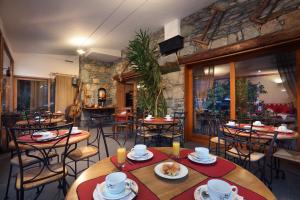 a restaurant with tables and chairs and a stone wall at Hotel Autantic in Bourg-Saint-Maurice