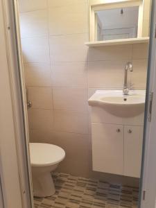a bathroom with a white sink and a toilet at Apartment Barbara in Kulen Vakuf +19 photos