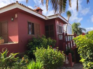 a red house with a fence in front of it at Chalet con vista in Montañeta