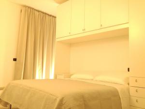 a white bedroom with a bed and a window at Il Cuore del Borgo - Holiday Home in Borgomaro