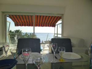 a table with wine glasses on it with a view of the ocean at Appartement Le Chantilly in Cagnes-sur-Mer