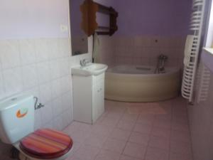 a bathroom with a toilet and a tub and a sink at Noclegi na Debinie in Gorzyce