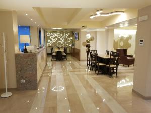 un vestíbulo con un restaurante con mesas y sillas en Hotel Motel 2, en Tortona
