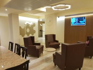 una sala de espera con sillas y TV en la pared en Hotel Motel 2 en Tortona