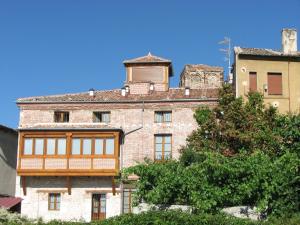 un viejo edificio de ladrillo con una torre encima en Aparthotel Santa Marina en Cuéllar