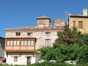 Un antiguo edificio de ladrillo con una torre en la parte superior. en Aparthotel Santa Marina, en Cuéllar