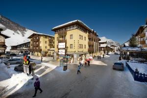 Un gruppo di persone che attraversa una strada in una citta' di Hotel Touring a Livigno