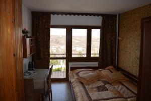 a bedroom with a bed and a large window at Pokoje Gościnne BARTEK in Iwonicz-Zdrój