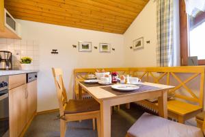 ein Esszimmer mit einem Tisch und einer Küche in der Unterkunft Ferienwohnungen Alpentraum - Landhaus Schmetterling in Oberstdorf