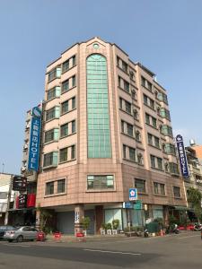 un edificio alto en una calle de la ciudad con una calle en Shiah Yih Hotel en Huwei