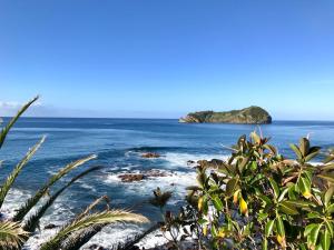 a view of the ocean with an island in the distance at A Villa by the Sea Bed & Breakfast in Vila Franca do Campo