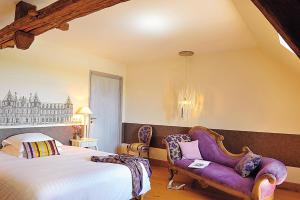 a bedroom with a bed and a purple chair at Logis Hôtel Le Relais Louis XI in Meung-sur-Loire