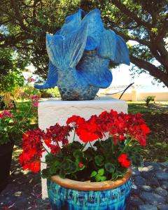 a statue of a flower pot with red flowers at A Villa by the Sea Bed & Breakfast in Vila Franca do Campo