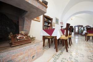 a dining room with a table and a brick fireplace at Agriturismo Villantica in Tuglie