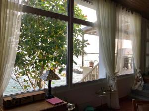 a room with two windows and a table with a lamp at A Villa by the Sea Bed & Breakfast in Vila Franca do Campo