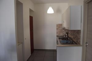 a kitchen with white cabinets and a tile floor at Riposto Etna Taormina Mare in Riposto