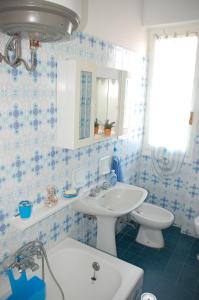 uma casa de banho azul e branca com um lavatório e um WC em San Michele em Arma di Taggia