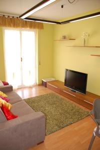 uma sala de estar com um sofá e uma televisão de ecrã plano em San Michele em Arma di Taggia