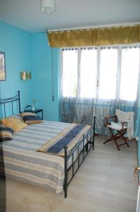 una camera da letto con un letto con pareti e finestre blu di San Michele ad Arma di Taggia