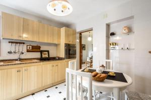 a kitchen with wooden cabinets and a table at Bewitched Granny's House in Pollença