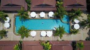 an overhead view of a swimming pool with white umbrellas at Le Piman Resort in Rawai Beach