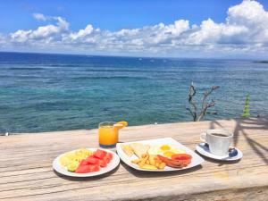 two plates of food on a table with the ocean at Twilight Ceningan in Nusa Lembongan